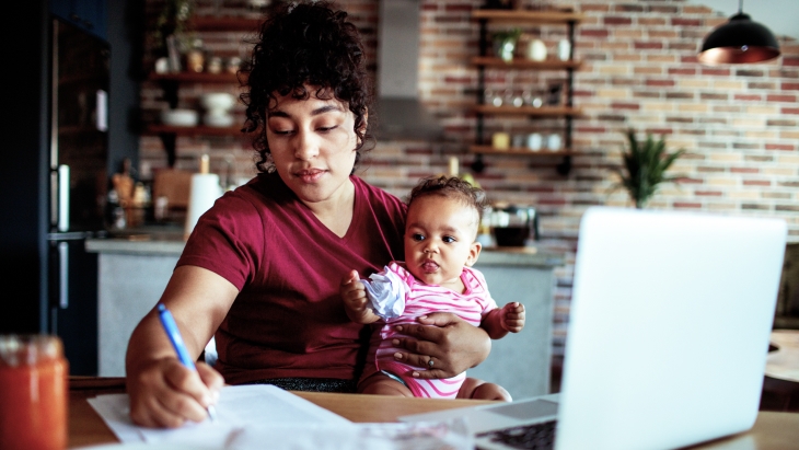 Mother doing bills with her infant daughter.