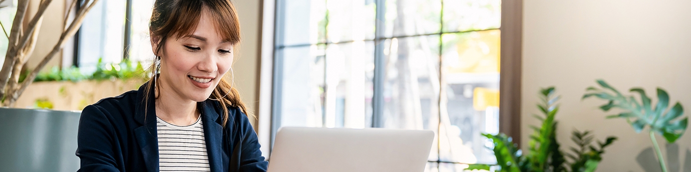 Businesswoman working on laptop at office desk.