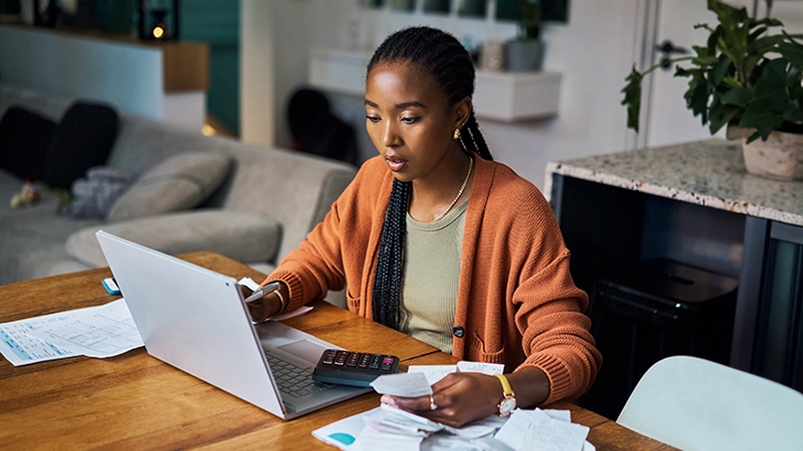 Woman confused while filing taxes on laptop at home.