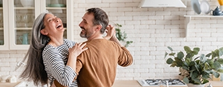 Feliz pareja bailando juntos en la cocina.