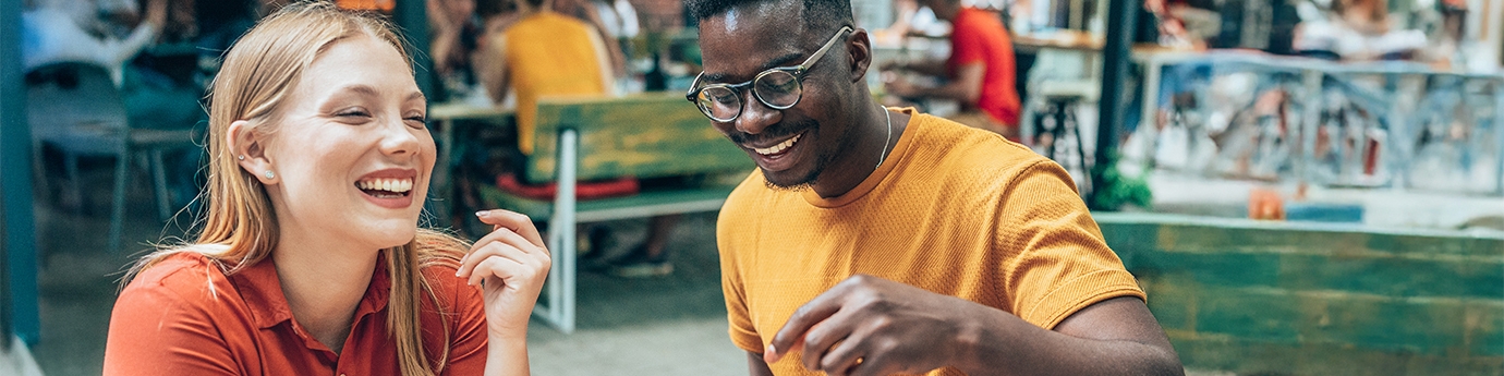 Friends having fun eating burgers and fries at an outdoor restaurant.