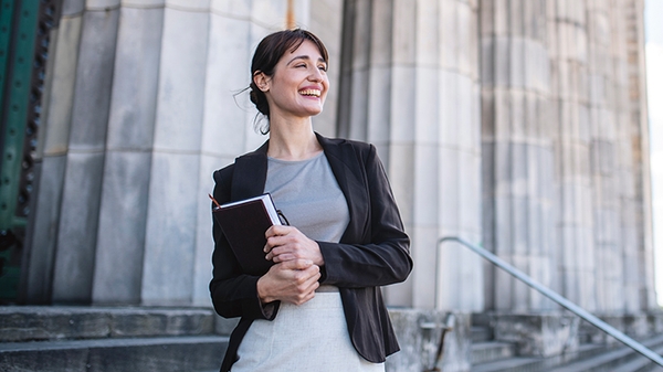 Businesswoman standing in front of government building columns