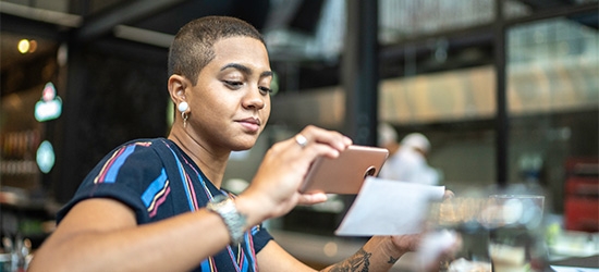 Woman depositing check with a mobile phone.