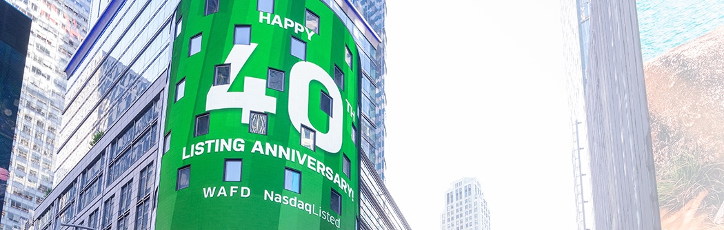 WaFd employees in Times Square NYC with WaFd Nasdaq sign