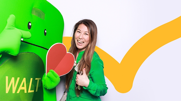 Walt mascot and WaFd employee smiling with heart cutout next to an America's Best Employers 2022 by Forbes badge