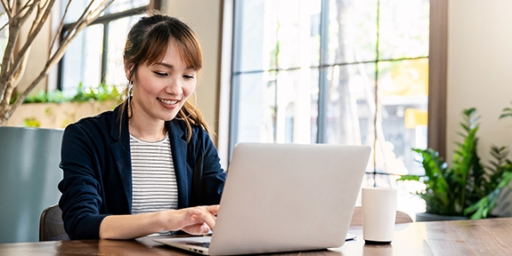 Businesswoman working on laptop at office desk.