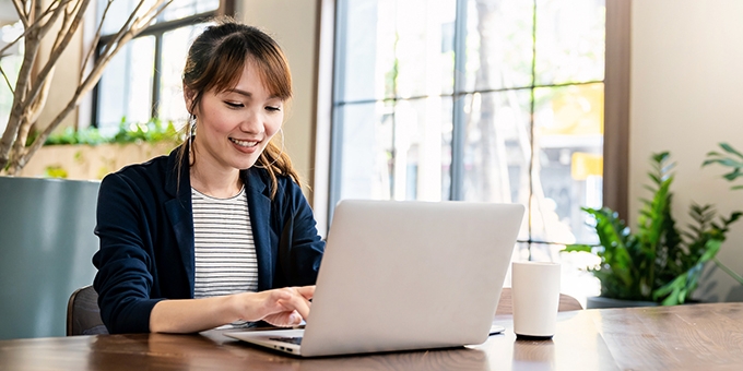Businesswoman working on laptop at office desk.