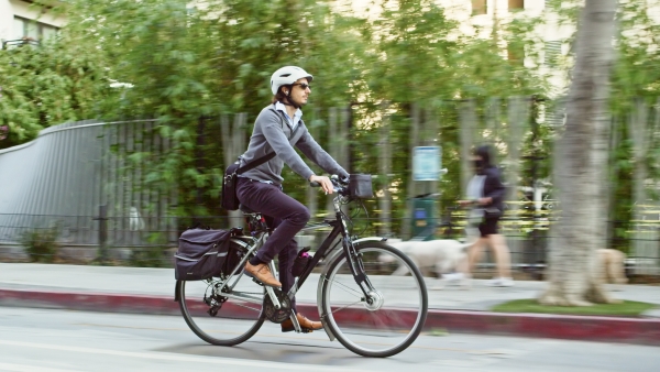 Man Riding in bike lane past city park