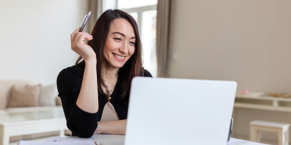 Smiling businesswoman working on laptop.