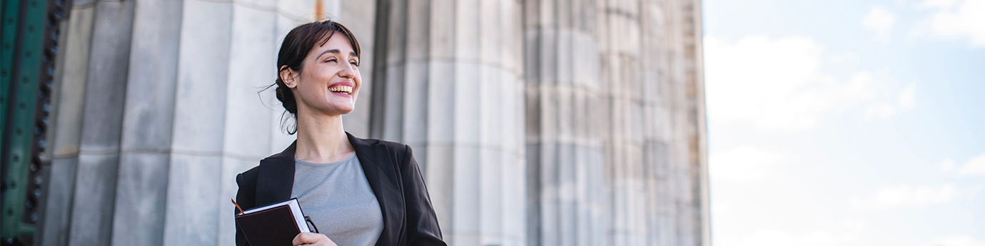 Businesswoman standing in front of government building columns 