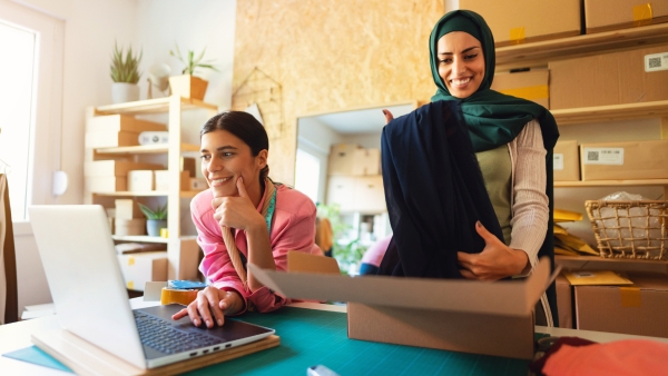 Smiling, Muslim businesswomen working together