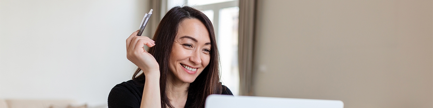 Smiling businesswoman working on laptop.
