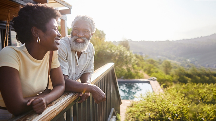 Happy couple talking on their home balcony.