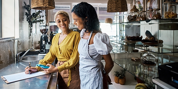 Business owner and employee in a shop reviewing financials.