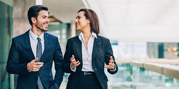 Two business people walking and talking in an office building