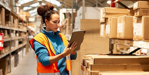 Woman using a tablet in a warehouse.