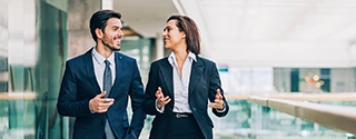 Two business people walking and talking in an office building.