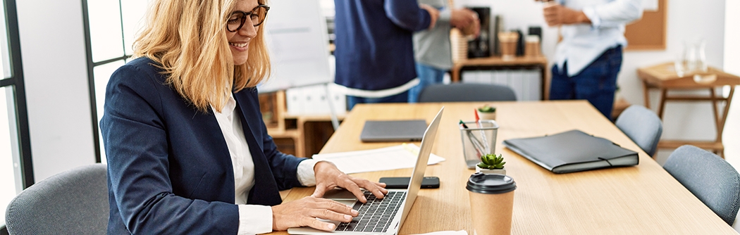Woman working on laptop in an office.