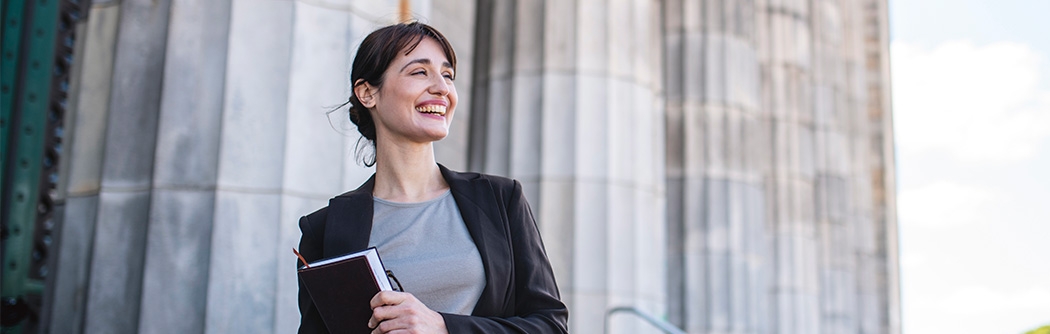 Businesswoman standing in front of government building columns.