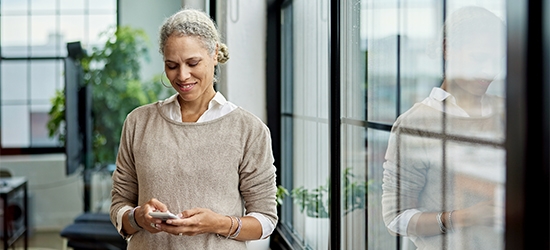 Businesswoman in office checking her mobile phone.