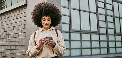 A young woman using WaFd Bank mobile app on her mobile phone.