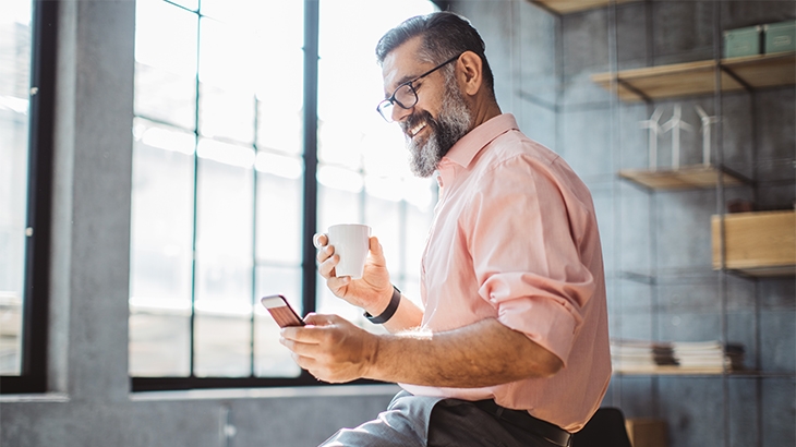 Businessman doing online banking on a mobile phone.