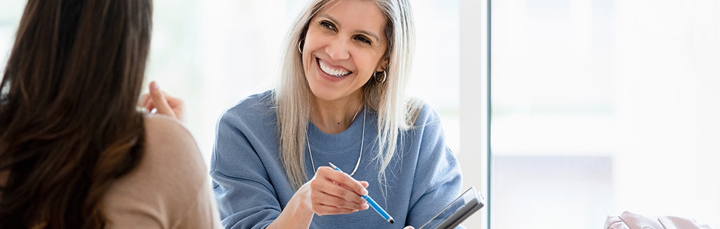 Two businesswomen reviewing a document on a tablet.