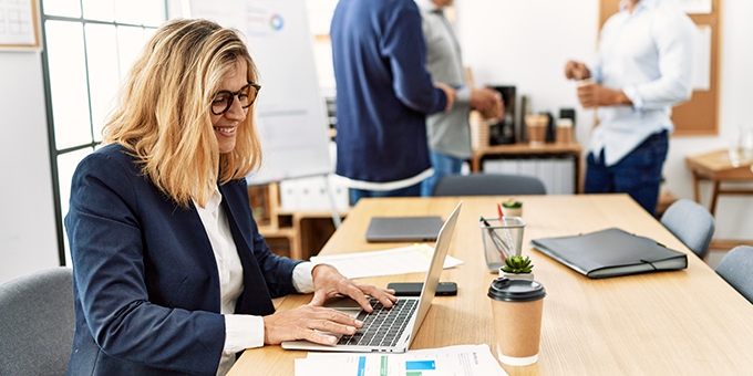 Woman working on laptop in an office.