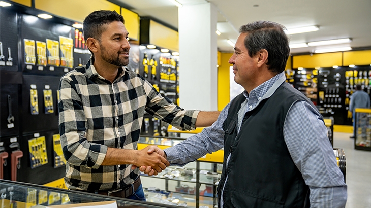A business owner shaking hands with a customer in an auto supply store.