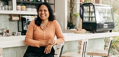 Business owner sitting at cafe bar stool.