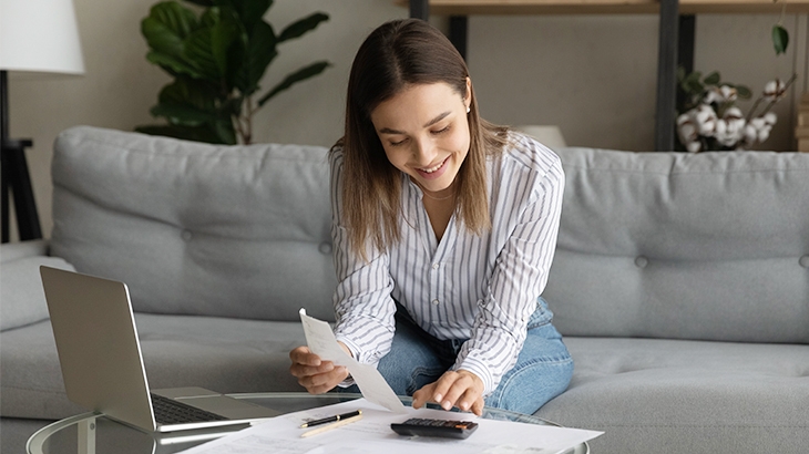 Young woman managing her finances on laptop.