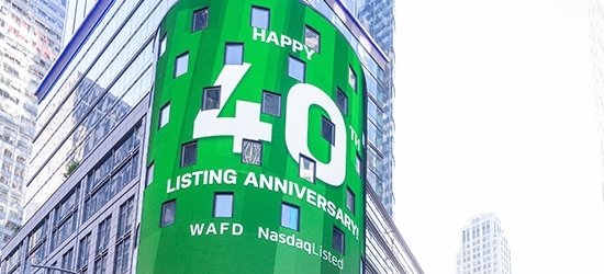 WaFd employees in Times Square NYC with WaFd Nasdaq sign