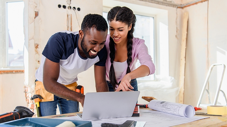 Couple looking at laptop during home renovation project.