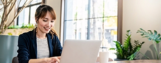 Businesswoman working on laptop at office desk.