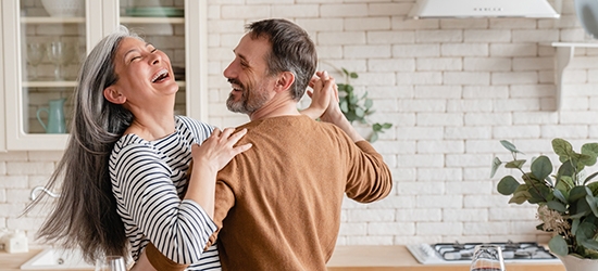 Feliz pareja bailando juntos en la cocina.