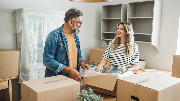 Mature couple moving items out of boxes into new home.