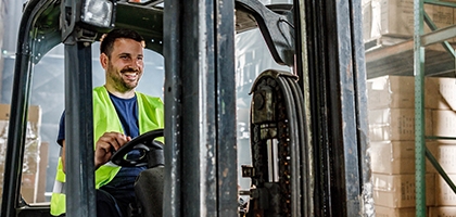 Warehouse worker driving a forklift in a storage room