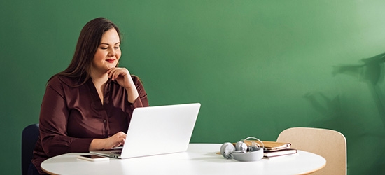 Businesswoman working on laptop at a table