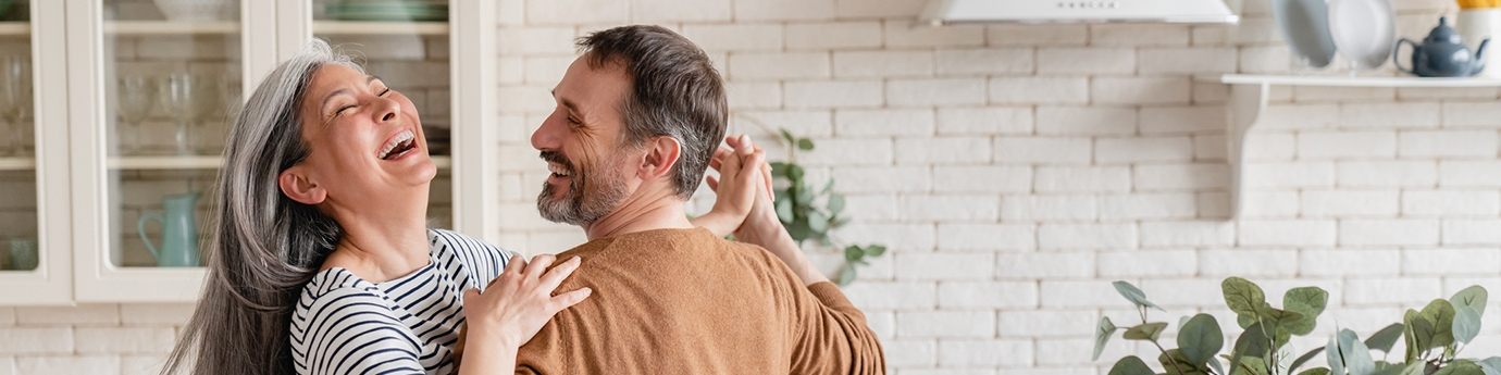 Feliz pareja bailando juntos en la cocina.