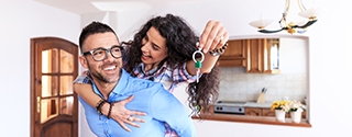 Young couple moving in new house, holding keys.