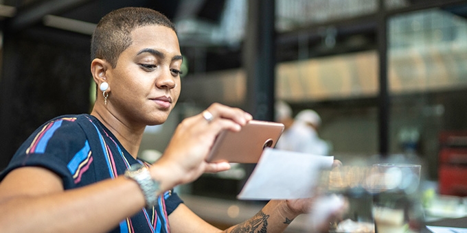 Woman depositing check with a mobile phone.