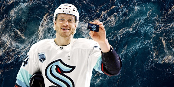 Hockey player holding a WaFd Seattle Kraken debit card.