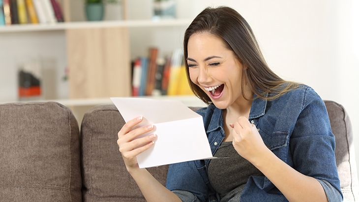 Woman celebrating, looking at tax refund statement.
