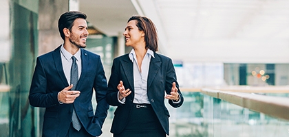 Two business people walking and talking in an office building