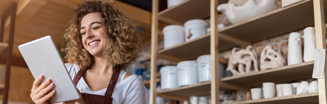 Craftswoman with tablet in her art studio.