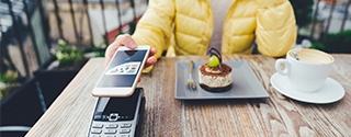 Woman paying for dessert with digital debit card mobile pay.