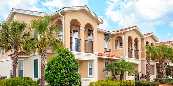 Senior housing building with tropical trees on a sunny day.