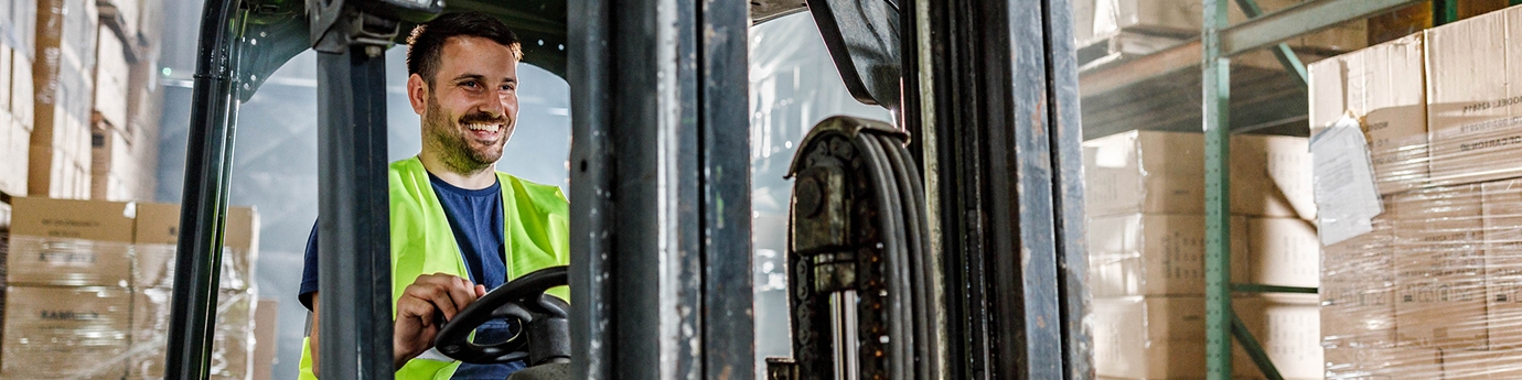 Warehouse worker driving a forklift in a storage room