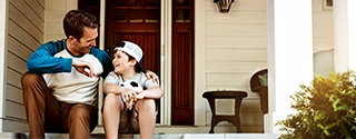 Father and his son laughing and talking on their porch at home