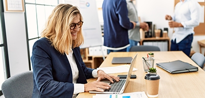 Woman working on laptop in an office.